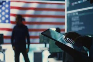 fintech ceo working in a IT environment with U.S. flag, focused on data protection information.